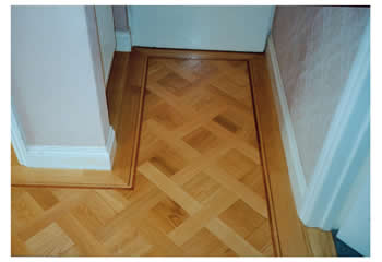New parquet flooring, Cambridge. Oak parquet in basket weave pattern with large dot design and mahogany two-line border..