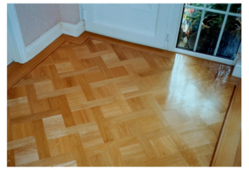 Laying new parquet wooden flooring in Cambridge. We were commissioned to lay this oak parquet wood flooring in a basket weave pattern with large dot inset and mahogany two-line border..