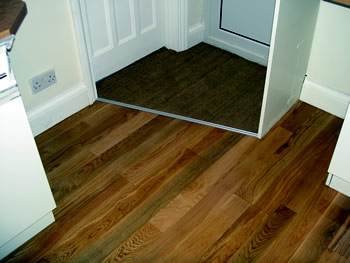 New wooden flooring, Finchley, London. Red oak engineered wood floor with door mat..